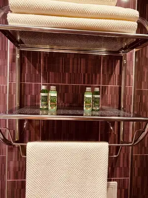 a towel rack with four towels on a shelf at Irina Apartment in Sandanski
