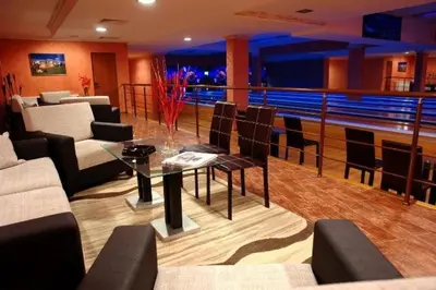 a living room with a table and chairs and a bowling at Grand Monastery Private Apartment in Pamporovo