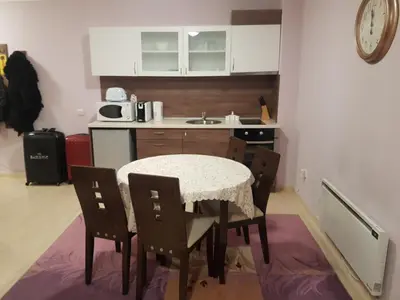 a kitchen with a table and chairs and a sink at Grand Monastery Private Apartment in Pamporovo
