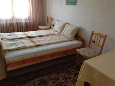 a bedroom with a bed with two chairs and a window at Katya Guest House in Smolyan