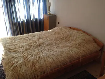 a bed with a furry blanket on top of it at Katya Guest House in Smolyan