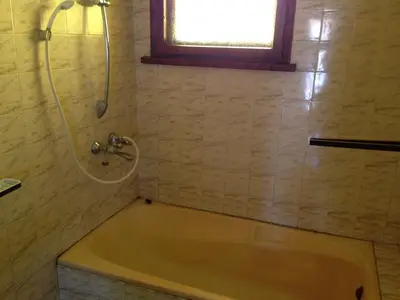 a bath tub in a bathroom with a window at Katya Guest House in Smolyan