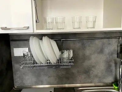 a kitchen with plates and glasses on a shelf at Mountain View Magenta White apartment in Sofia
