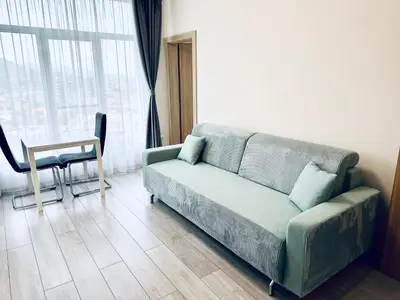 a living room with a couch and a table at Mountain View Magenta White apartment in Sofia
