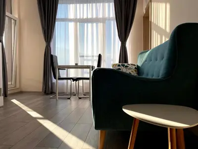a living room with a green couch and a table at Mountain View Magenta White apartment in Sofia