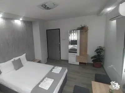 a small bedroom with a bed and a kitchen at Каламанди in Asenovgrad