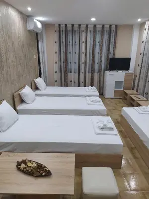 a hotel room with two beds and a tray of food at Каламанди in Asenovgrad