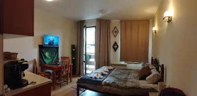 a bedroom with a bed and a kitchen with a window at GONDOLAs LODGE in Bansko