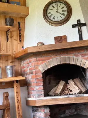 a clock on a wall above a brick fireplace at Villa Rila Garden in Beli Iskar