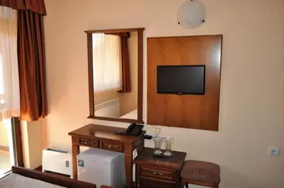 a hotel room with a mirror and a television at Spartak Family Hotel in Smolyan