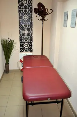a red bench in a waiting room with a phone at Spartak Family Hotel in Smolyan