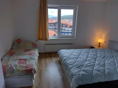 a bedroom with a bed and a window at Apartment BanskoIN in Bansko