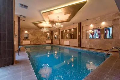 a swimming pool in a hotel with a chandelier at Apartment BanskoIN in Bansko
