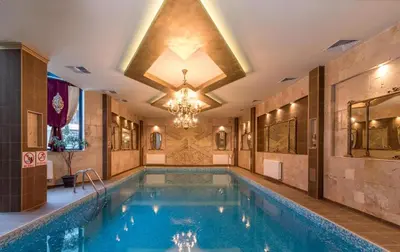a pool in a building with a chandelier at Apartment BanskoIN in Bansko