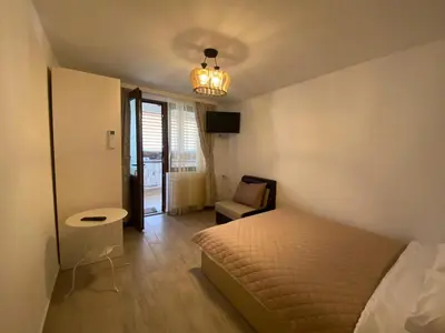 a bedroom with a bed and a chair in it at Къща за гости детелина - лина in Sapareva Banya