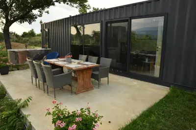 a patio with a table and chairs in front of a building at HomeRevolution in Marikostinovo