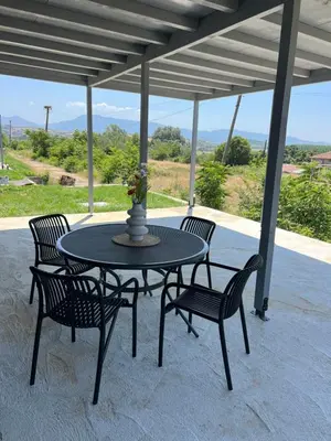 a table with four chairs and a vase on it at HomeRevolution in Marikostinovo