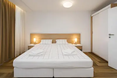 a large white bed in a room with two lamps at North Panoramic Apartment in the art district of Kapana in Plovdiv