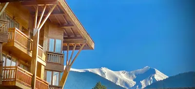 a building with a view of a snow covered mountain at Pirin Golf Hotel Private Apartments Апартаменти Планински Изгрев в Пирин Голф in Razlog