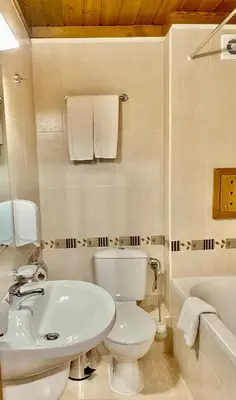a white bathroom with a toilet and a sink at Pirin Golf Hotel Private Apartments Апартаменти Планински Изгрев в Пирин Голф in Razlog