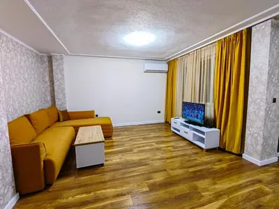 a living room with a yellow couch and a tv at Sofia hotel apartments in Sofia