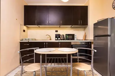a kitchen with a table and chairs and a refrigerator at Cozy new Apartment 'Casa Vacanza ' ✵ TOP CENTER ✵ in Plovdiv