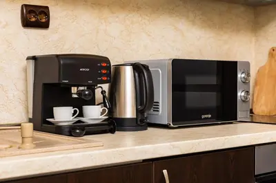 a microwave sitting on a kitchen counter with two coffee cups at Cozy new Apartment 'Casa Vacanza ' ✵ TOP CENTER ✵ in Plovdiv