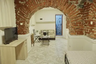 a living room with a tv and a brick wall at Top Center Detached Apartment Studio in Sofia