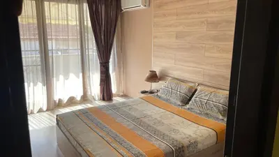 a bedroom with a bed and a large window at Thea Apart in Sandanski