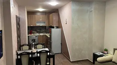 a small kitchen with a refrigerator and a table and chairs at Thea Apart in Sandanski