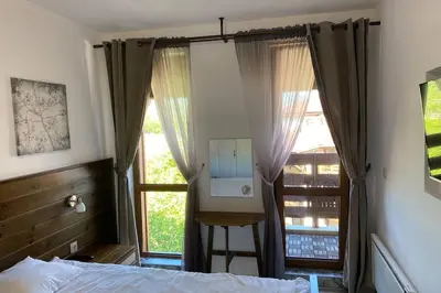 a bedroom with a mirror in front of a window at Belvedere Holiday Club VIP Apartment H 82 in Bansko