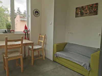 a living room with a table and a chair and a couch at Brand New Apartment in Sofia