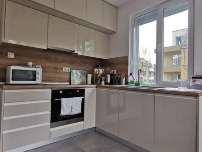 a kitchen with white cabinets and a microwave at Brand New Apartment in Sofia