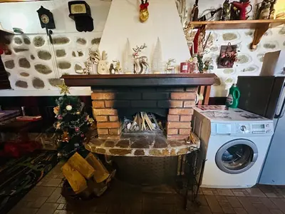 a living room with a fireplace and a washing machine at Къща за гости Даутев Връх in Bansko