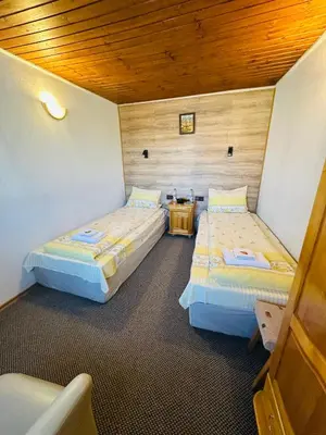 a room with two beds and a table in it at Къща за гости Даутев Връх in Bansko