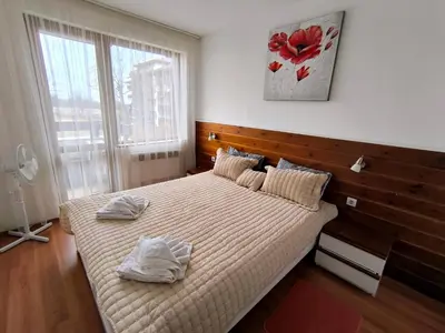 a bedroom with a bed with two towels on it at Belvedere Holiday Club Private Apartment in Bansko