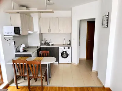 a kitchen with a table and chairs in a room at Belvedere Holiday Club Private Apartment in Bansko