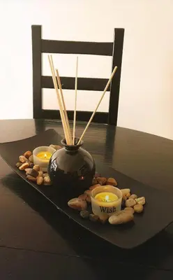 a black vase with three candles and peanuts on a table at Lovely City Center 1BD, 1BT Apartment in Sofia