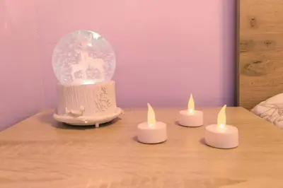 four candles sitting on a table with a snow globe at Lovely City Center 1BD, 1BT Apartment in Sofia