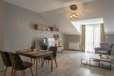 a dining room and living room with a table and chairs at Luxury 2-bedroom apartment by Studenets Center by Flat Mаnager in Pamporovo