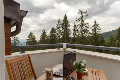 a laptop computer sitting on a table on a balcony at Luxury 2-bedroom apartment by Studenets Center by Flat Mаnager in Pamporovo