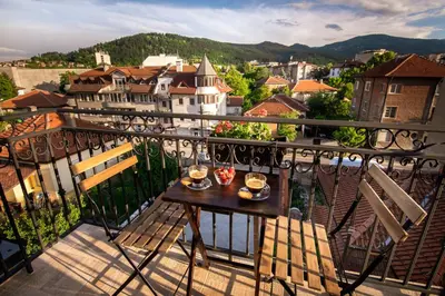 a balcony with a table and chairs and a city at Family Hotel Konstantinovi in Kyustendil
