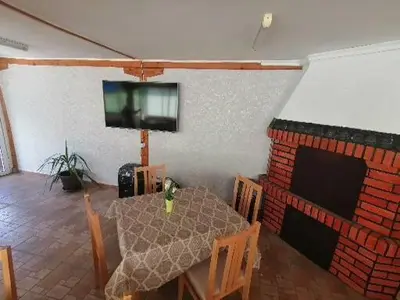 a dining room with a table and a television on a wall at Guest House Shipkovo Hills in Shipkovo