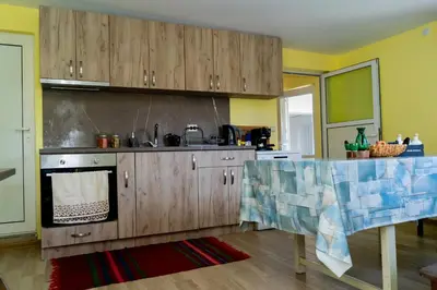 a kitchen with wooden cabinets and a stove top oven at Къща Лиляна in Resilovo