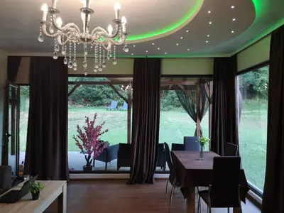 a dining room with a table and a chandelier at Вила Мая 2 in Krayni Dol