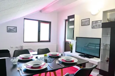 a living room with a dining table and a television at Discovery Apartment Bansko in Bansko