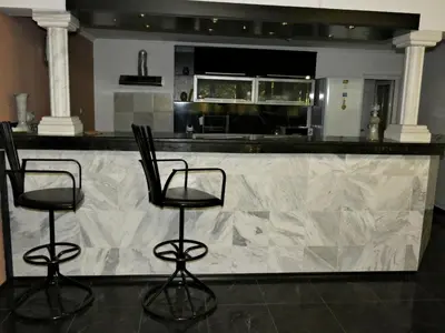 a kitchen with two bar stools in front of a counter at Grande - Velingrad in Velingrad