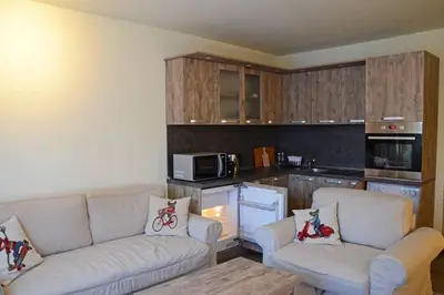a living room with two couches and a kitchen at Cozy One Bedroom Apartment in Iglika Complex in Borovets