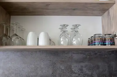 a shelf with glass bottles and vases on it at Cozy One Bedroom Apartment in Iglika Complex in Borovets