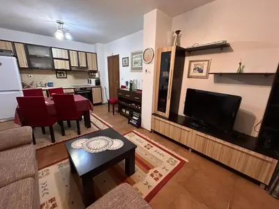 a living room with a couch and a tv and a kitchen at Апартамент Планинско Гнездо - Mountain Nest in Stoykite